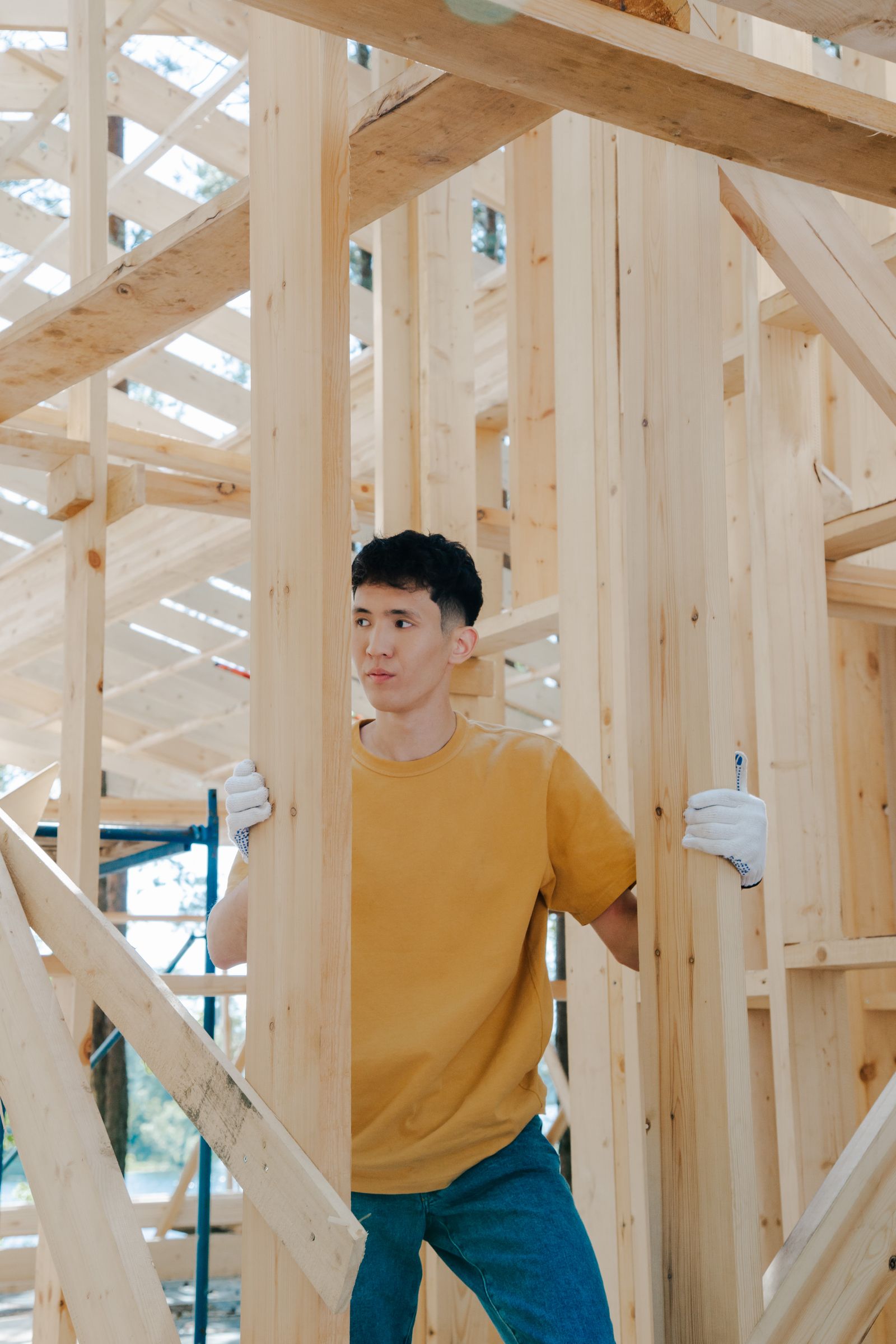 A worker inside the wood framing of a house under construction
